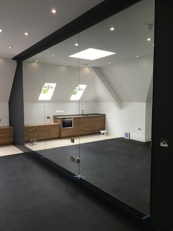 Frameless glass partition in loft conversion by Hammersmith glaziers